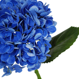 Een close-up van de Kunstbloem Charlotte Hortensia Real Touch in donkerblauw (55 cm), met een levendige blauwe kunsthortensiabloem met groen blad en steel, tegen een witte achtergrond.