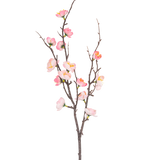 De Kunsttak Prunus 78 cm roze heeft een enkele donkerbruine tak met kleinere uitlopers, versierd met roze en witte kersenbloesembloemen en groene knoppen, tegen een effen witte achtergrond.