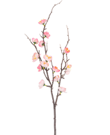 De Kunsttak Prunus 78 cm roze heeft een enkele donkerbruine tak met kleinere uitlopers, versierd met roze en witte kersenbloesembloemen en groene knoppen, tegen een effen witte achtergrond.