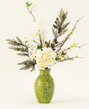 Het Zijden kunstbloemen boeket Earthlight is gearrangeerd in een vaas met groene structuur, met witte hortensia's, delicate witte bloesems en groenbruin gebladerte tegen een effen lichte achtergrond.