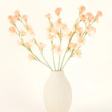 De crèmekleurige vaas van keramiek bevat het Zijden kunstbloemen boeket Erwt perzik, met delicate perzik- en lichtroze bloemen met lange groene stelen tegen een lichte, neutrale achtergrond.