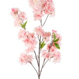 De Kunstbloem Kersenbloesem 119 cm roze heeft meerdere trossen lichtroze kersenbloesem bloemen en groene bladeren op een tak, tegen een witte achtergrond.