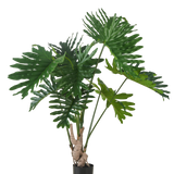 De Kunstplant Philodendron 150 cm heeft grote, glanzende, diep gelobde groene bladeren aan lange stengels, tegen een effen witte achtergrond.