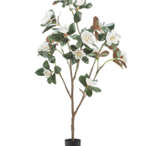 De Kunstplant Yulania 150 cm met bloem is een hoge kunstmagnolia met meerdere takken, weelderige groene bladeren en witte bloemen in een kleine zwarte pot, tegen een effen witte achtergrond.