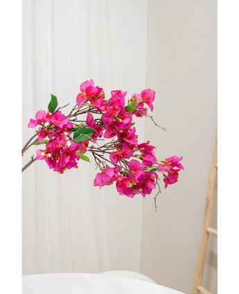 De Kunstbloem Bougainvillea 90 cm paars, met levendige paarse bloemen en groene bladeren, wordt getoond tegen een lichte neutrale achtergrond naast een houten ladder aan de rechterkant.