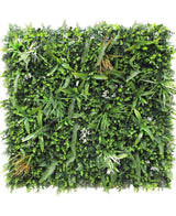 De Kunsthaag mat Savanne 100x100 cm is een vierkant groen wandpaneel dicht bedekt met UV-beschermde kunstvarens, grasachtige bladeren en kleine witte bloemen voor een weelderige, natuurlijke uitstraling in elke ruimte.