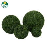 Vier Kunstplant Buxus Romeinse stijl UV D30cm kunstige buxusbollen zijn gegroepeerd op een witte achtergrond, met een UV-bestendig symbool in de linkerbovenhoek.