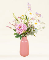 Een roze vaas toont het Zijden kunstbloemen boeket Misty Minthe, met witte margrieten, roze pioenrozen, paarse bloesems en eucalyptustakjes, tegen een lichte neutrale achtergrond.