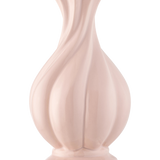 De Vaas Little Fairy 26 cm roze is een glanzende, lichtroze vaas van keramiek met een uitlopende rand en gebeeldhouwde wervelende groeven, ideaal voor het uitstallen van een zijden kunstbloemen boeket. Afgebeeld tegen een effen witte achtergrond.