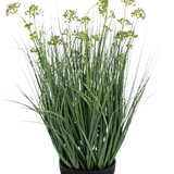 De Kunstgras Prei Bloem Ui Graspot 60cm brandvertragend heeft lange, dunne groene bladeren en lange stelen met geelgroene bloemtrossen in een zwarte pot, afgebeeld op een witte achtergrond.