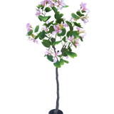 De Kunstplant Judas 150 cm is een kunstplant in pot met groene bladeren en talrijke lichtroze bloemen tegen een effen witte achtergrond.