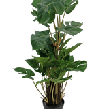 De Kunstplant Monstera 90 cm is een kunstplant met grote, glanzend groene bladeren met natuurlijke splitten, rechtop in een zwarte pot tegen een effen witte achtergrond.